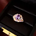 Gedetailleerd overzicht van luxe 18k goud vergulde ovale ring met paarse stenen in doos. - Open Ring (HR3977) / Goud-Paars