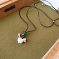 Vista detallada de un colgante de pájaro plateado cepillado en un cordón ajustable - Pájaro