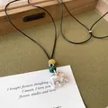 Primer plano detallado del colgante elefante de plata cepillada con cuentas verdes y amarillas - Elefante