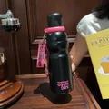 Macro detail of matte black sports water bottle with vibrant pink handle and logo - 520ml / Black