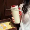 Close-up view of a cream-colored 316 stainless steel coffee thermos cup with red lid detail - 550ml / Creamy White With Red Lid
