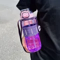 Large purple sports water bottle with straw and shoulder strap held in hand outdoors. - 750ml / Purple