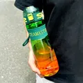 Close-up detail of a gradient green and orange sports water bottle with measurement scales - 950ML / Green-Orange Gradient