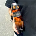 Detailed view of large gradient sports water bottle held by a person outdoors - 950ML / Black Orange Gradient