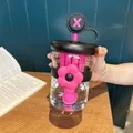 Close-up view of a clear plastic tea separation water bottle with a pink flower accessory - 500ml / Black