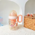 Detailansicht eines niedlichen Milchbechers in Babyflaschenform mit Bärenmuster und Griff - 380ml / SLB6117 Kunststoffbecher-Kaffee