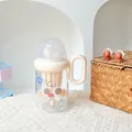 Kreative cremefarbene Tritan-Milchtasse mit süßem Cartoon-Gesicht und ergonomischem Griff - 380ml / SLB6118 Kunststoffbecher-Überraschung ohne Blinzeln