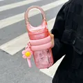Close-up view of a stylish pink portable water bottle with flower charm and handle - 450ml / Pink