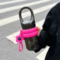 Close-up of a black portable water bottle with pink silicone sleeve and flower charm - 450ml / Black