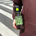 Close-up view of a trendy sports water bottle with Street Music graffiti design in hand. - 700ml / Black Green
