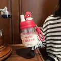 Detail view of a cute red glass water bottle with a cartoon character and carry strap - 500ml / Red