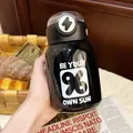 Minimalist black stainless steel vacuum insulated water bottle with straw being held by hand - 500ml / Black (White Letter Print)