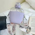 Purple plastic water bottle with straw and wide floral strap held in a lifestyle setting - 700ml / Purple