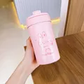 Vue détaillée d'une main tenant un joli gobelet isotherme rose au motif de lapin - Style Lapin / 550ml / Rose