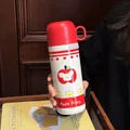 Detailansicht der süßen Apple Diary Thermosflasche aus Edelstahl mit rotem Deckel - Cartoon Apfel (DD3040)