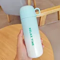 Hand holding a gradient light blue and white vacuum flask bottle with a handle - 500ml / Green