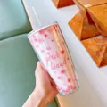 Détail d'un gobelet à double paroi motif fleurs de cerisier avec paille et logo - 750ml / Rose