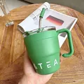 Detail einer minimalistischen grünen Kaffeetasse aus Edelstahl mit Griff und Strohhalm - 480ml / Grün
