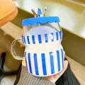 Macro view of a Klein Blue striped glass mug featuring an elegant silver crown lid. - Yellow Stripe / 450ml / Striped