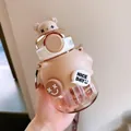 Cute beige bear-shaped children's cartoon straw water bottle with a portable strap - 730ml / Brown