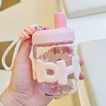 Détail d'une bouteille d'eau portable en verre avec housse en silicone rose et dragonne - 400ml / Rose