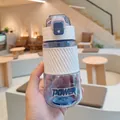Gourde de sport en plastique violet avec manchon en silicone blanc en main - 500ml / Direct Drinking Type (BK8021) / Crème