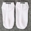 Close-up of white boat socks featuring black SMOKE and DRINK embroidery on heels - One Size / SMOKE DRINK / White
