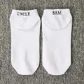 Detail view of white men's ankle socks featuring 'Uncle Sam' black embroidery - One Size / UNCLE SAM / White