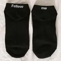 Detail of black low-cut socks with white Follow Me text embroidery on the heels - One Size / FOLLOW ME / Black