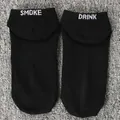 Close-up of black funny socks featuring white embroidered SMOKE and DRINK text on top. - One Size / SMOKE DRINK / Black