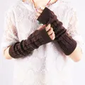 Macro view of brown cable-knit fingerless arm warmers worn over a white lace top. - Coffee