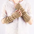 Close-up detail of khaki cable knit fingerless arm warmers on white lace top. - Camel