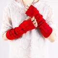 Close-up of vibrant red cable-knit long arm warmers against a white lace top background. - Red