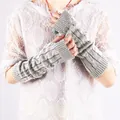 Detailed macro view of grey cable knit long fingerless arm warmers worn by a model - Light Gray