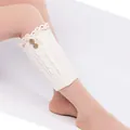 Soft cream white knit leg warmers featuring elegant lace trim and two wooden buttons - One Size / White