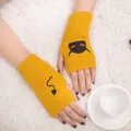 Close-up of yellow knitted fingerless gloves with black devil embroidery on white fur - Devil Pattern Fingerless Gloves (ST19 Devil Tail) / Yellow