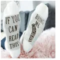 Detailed view of white mid-tube cotton socks with funny chocolate letter print on soles. - One Size / White