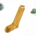 Elegant mustard yellow cable knit knee high sock featuring delicate white lace trim design - One Size / Turmeric