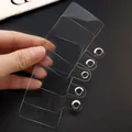 Macro view of multiple transparent phone tether tabs with durable metal grommets for lanyards - 1 Piece / Transparent Insert