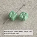 Close-up detail of mint green acrylic cheese-shaped cube beads with 10mm dimensions - Turquoise Green