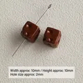 Detailed close-up of small brown acrylic cheese-shaped square beads with 2mm hole - Dark Coffee