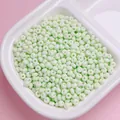 Gedetailleerde close-up van 4mm lichtgroene matte macaron glazen kralen in witte schaal - 200 Stuks / 18 (ai-Light Green)