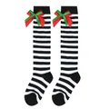 Close-up of children's striped knee-high Christmas socks with red and green bows - Kids (7-12 Years) / Double Layer Bow / Black & White Thin Stripes