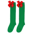 Close-up detail of green children's Christmas knee-high socks featuring large red bows - Kids (7-12 Years) / Pure Green/Red Bow