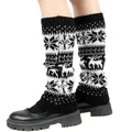 Detail view of knitted leg warmers with festive white snowflake and reindeer patterns - One Size / Black
