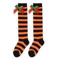 Close-up of children's orange and black striped knee-high socks with festive bows - Kids (7-12 Years) / Double Layer Bow / Orange & Black Stripes