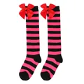 Close-up of pink and black striped girl's knee-high socks with red satin bows - Kids (7-12 Years) / Black/Rose Red Stripes with Red Bow
