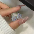 Vista detallada de los brillantes pendientes de moissanita con forma de gota en la mano - Pendientes de Moissanita Gota de Agua Copo de Nieve / Plata