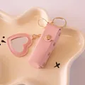 Elegant pink faux leather lipstick case keychain featuring a heart-shaped makeup mirror - Pink