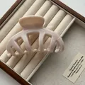 Detail of a large beige Korean style hair claw clip displayed in a wooden jewelry box. - Jelly Light Coffee